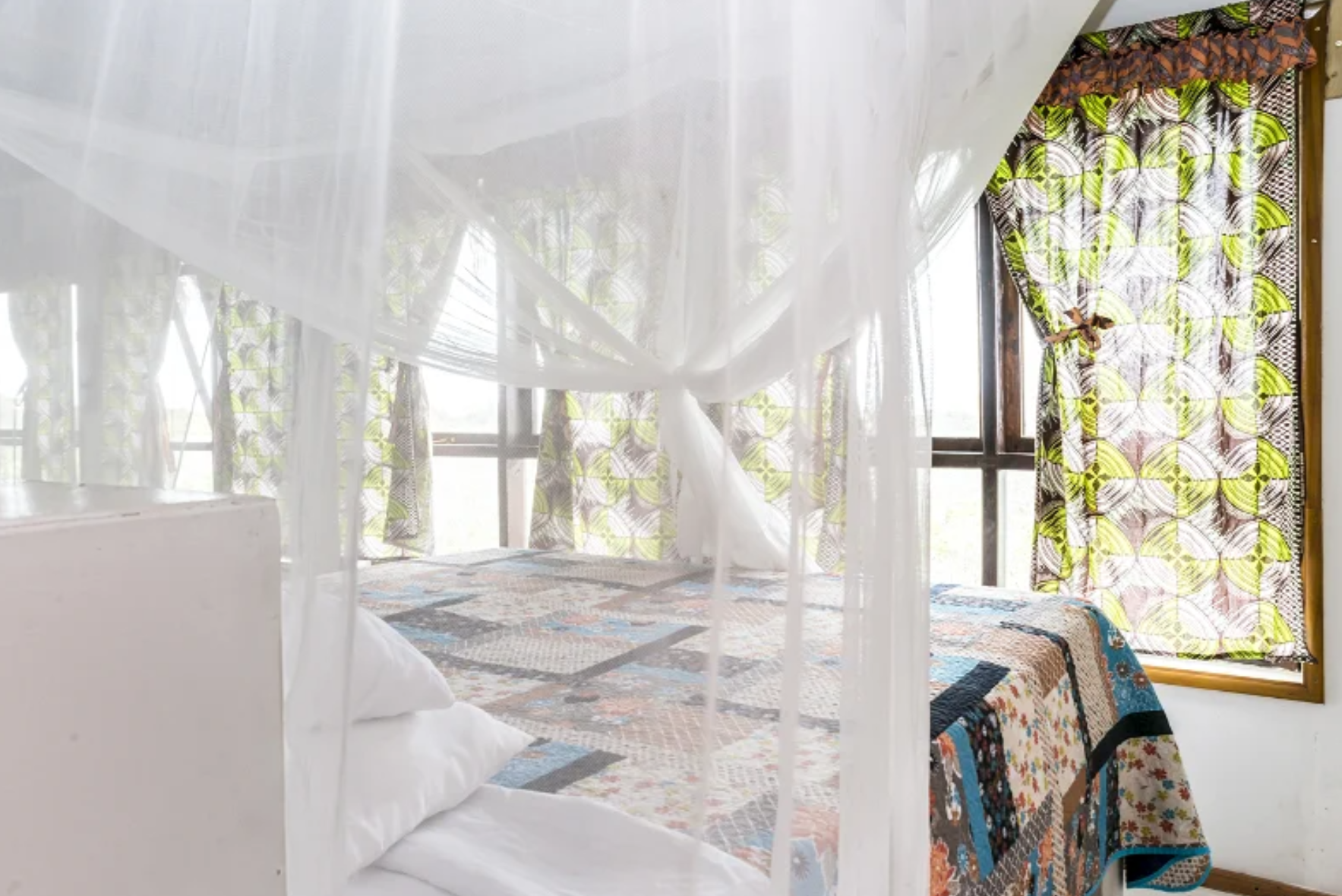 Bedroom with patchwork quilt and patterned curtains