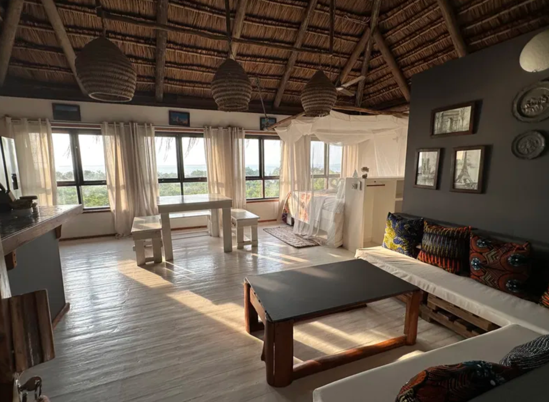Upstairs living area under a thatched roof with bay views