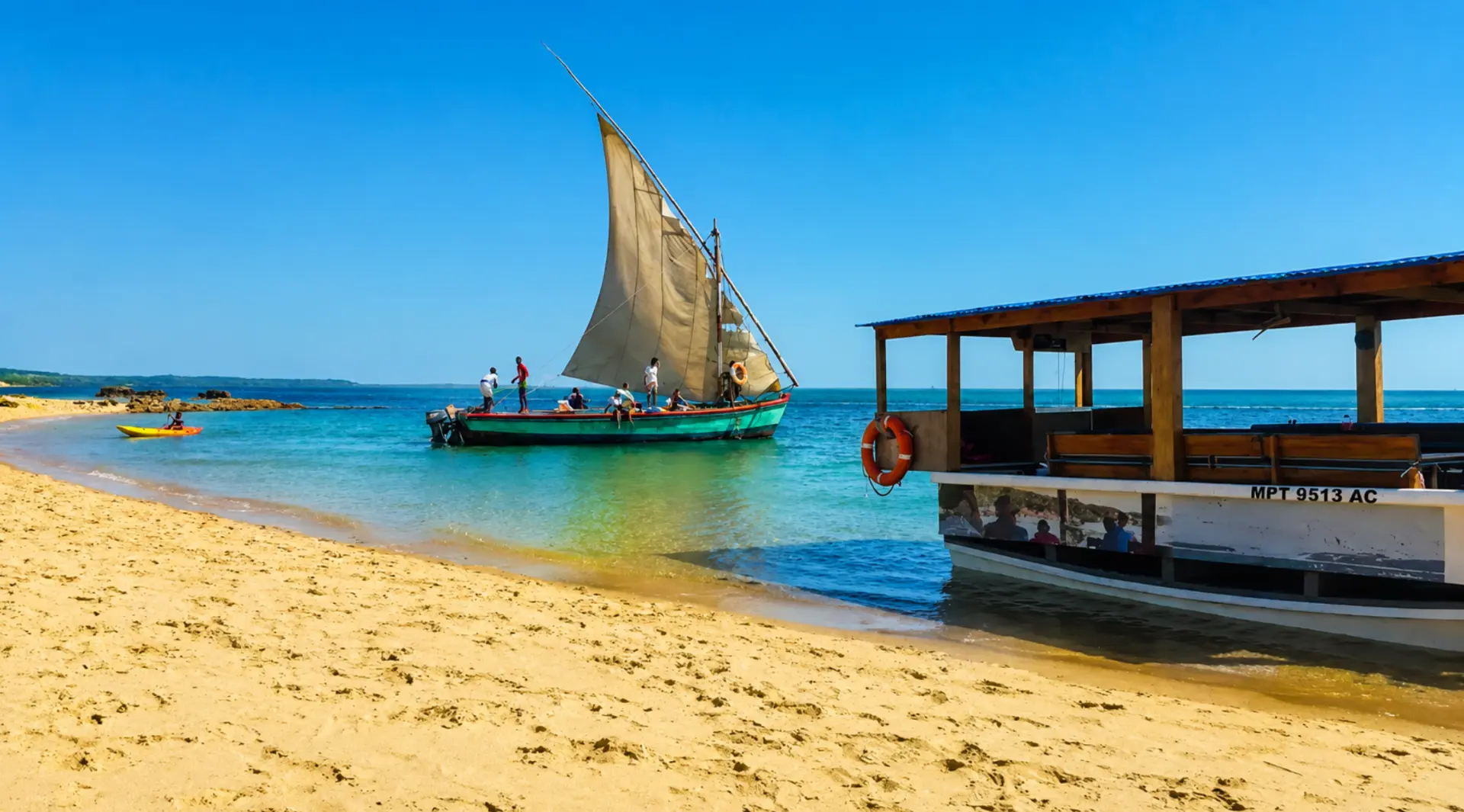 Colourful dhow boat anchored on a sandy Santa Maria beach under bright blue skies