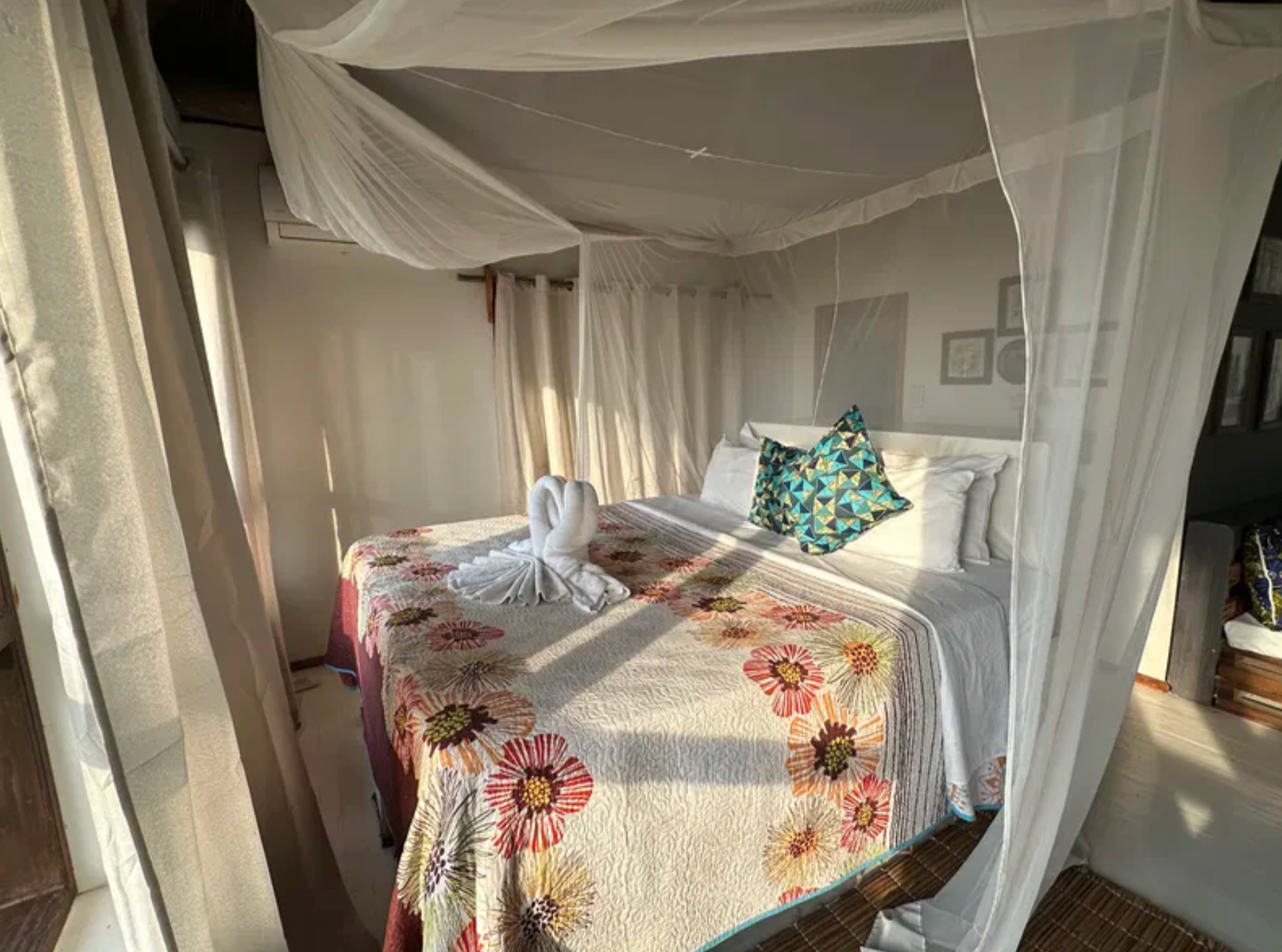 Bedroom with mosquito net and floral quilt