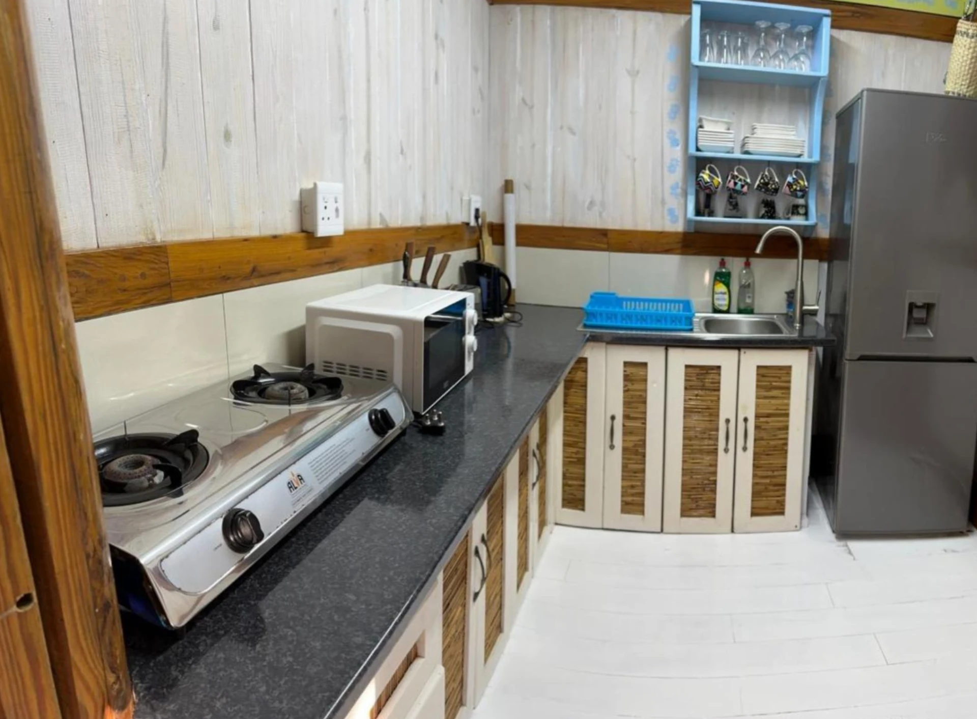 Kitchen with counter, stove, microwave and fridge