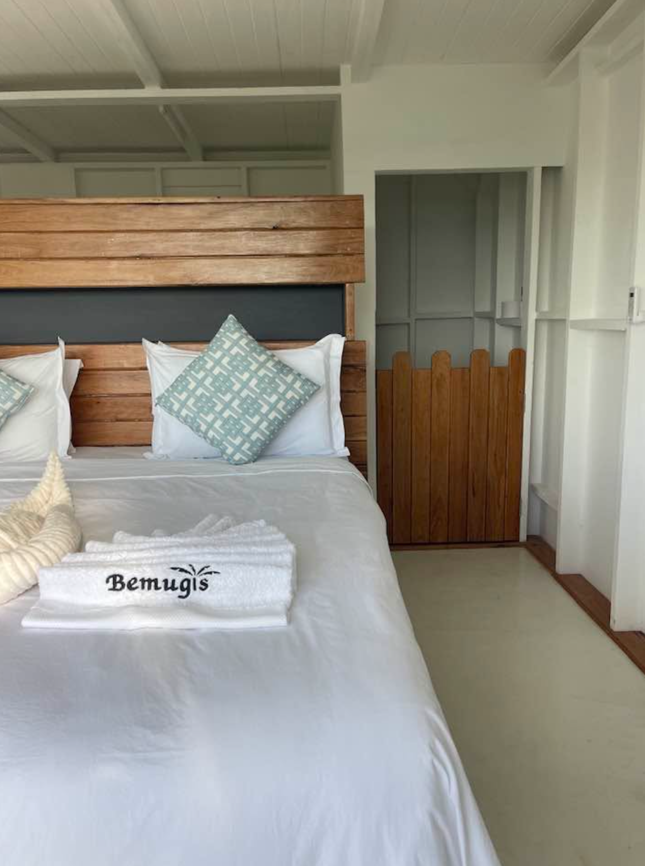 Bedroom with Bemugi's towels and wooden headboard