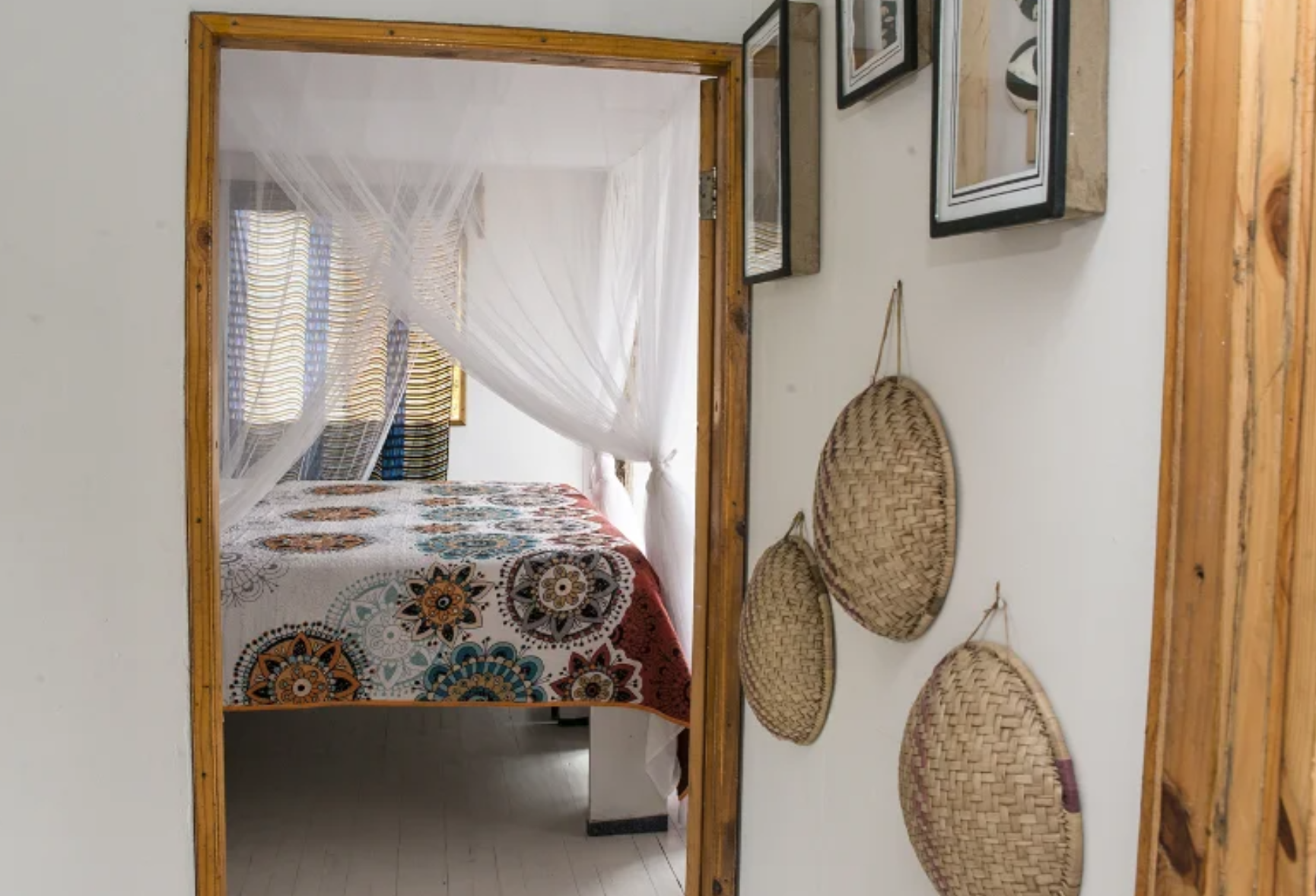 Bedroom seen through the doorway with woven wall baskets