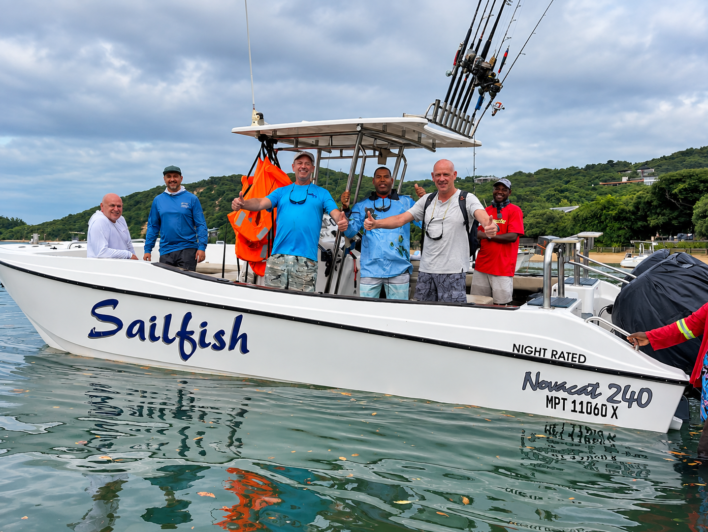 Five guests and crew on the deck of the white Sailfish charter boat in Santa Maria bay with fishing rods rigged overhead
