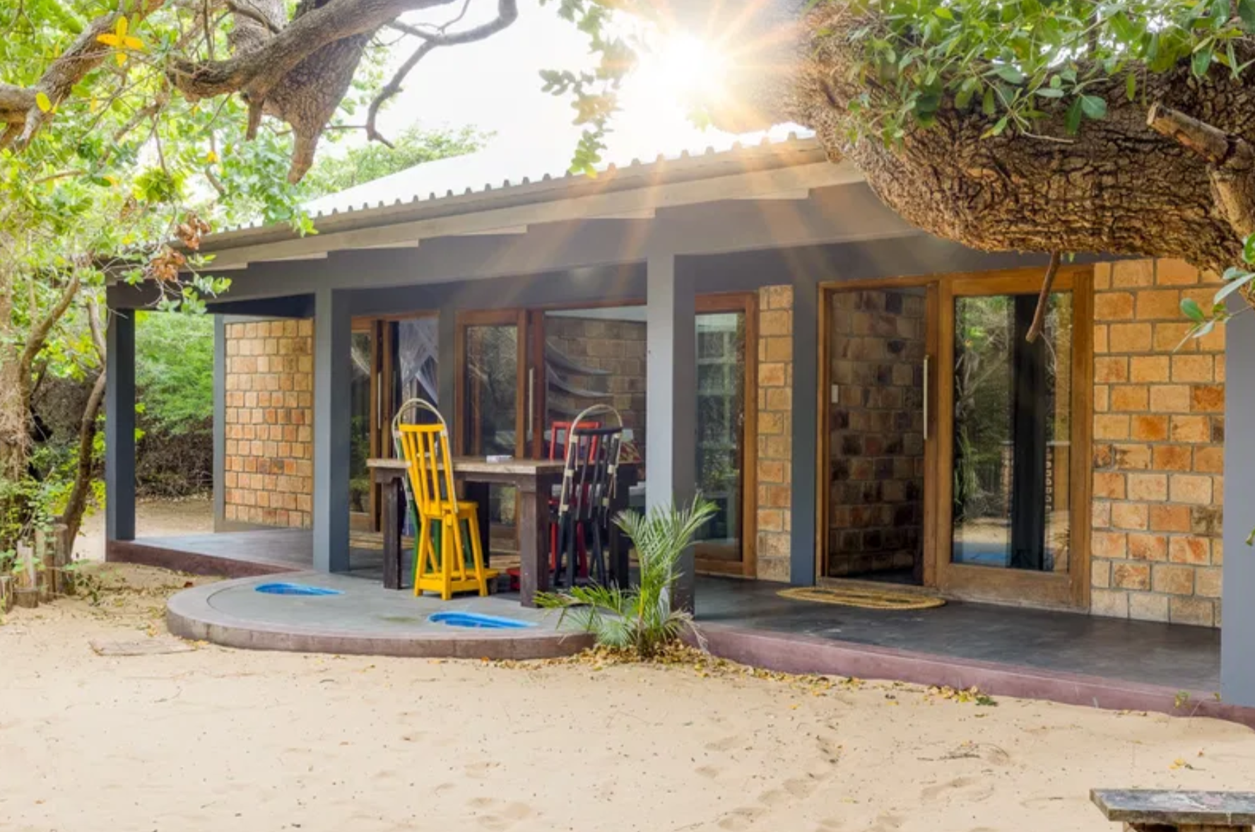Outdoor dining patio under coastal trees