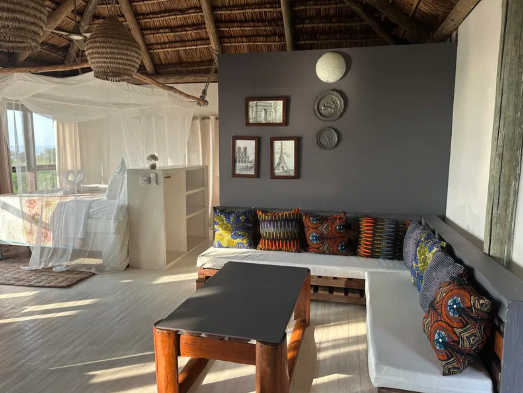 Upstairs lounge with patterned cushions and bed beyond