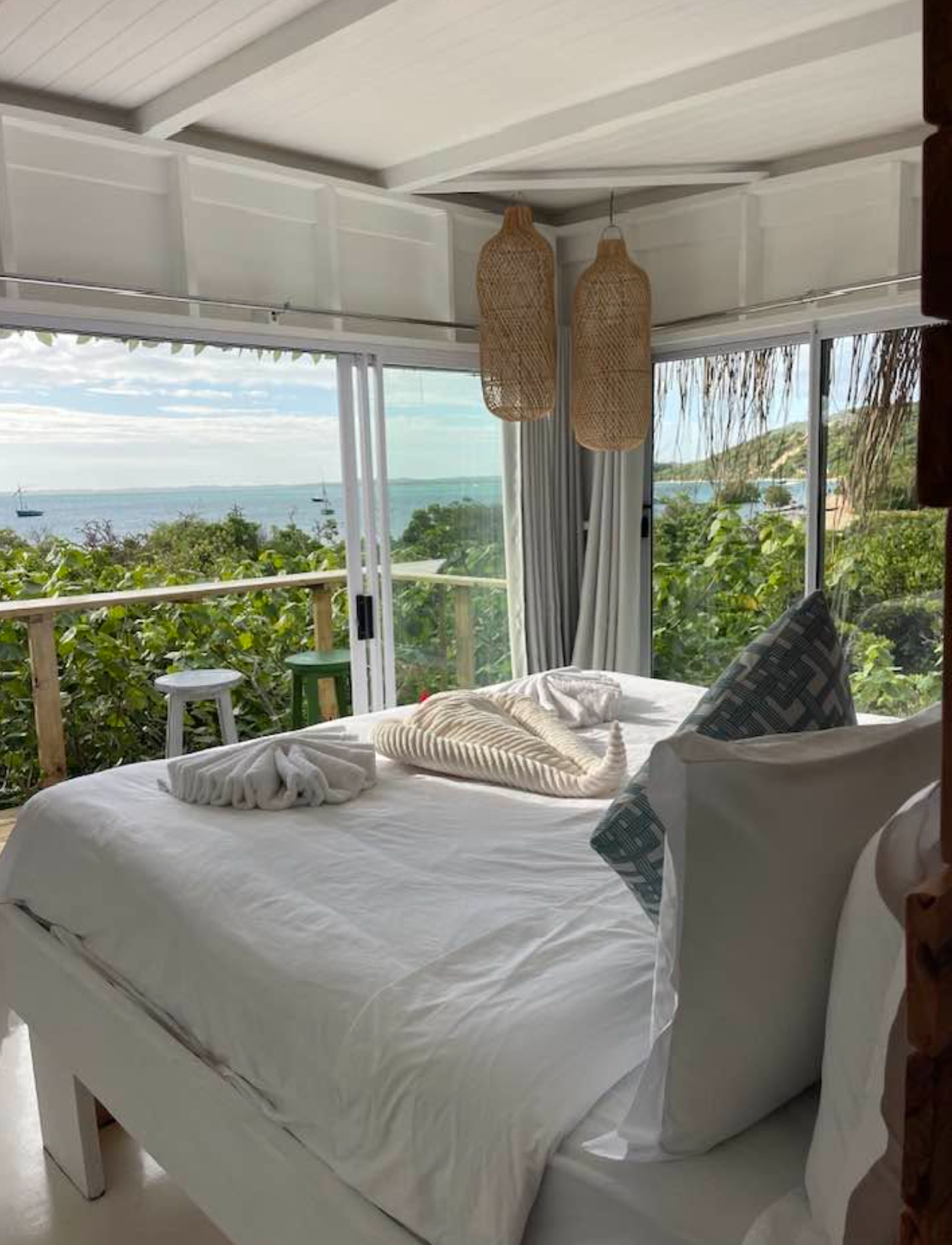 One Bedroom Bay View bedroom with woven pendant lights and views across Maputo Bay towards Inhaca Island