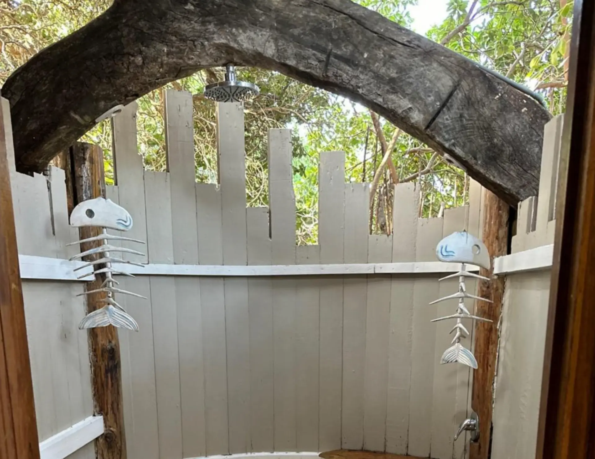 Outdoor shower with wooden privacy screen and fishbone decor